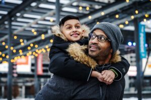 Man with child on his back, having fun at celebration square in Mississauga